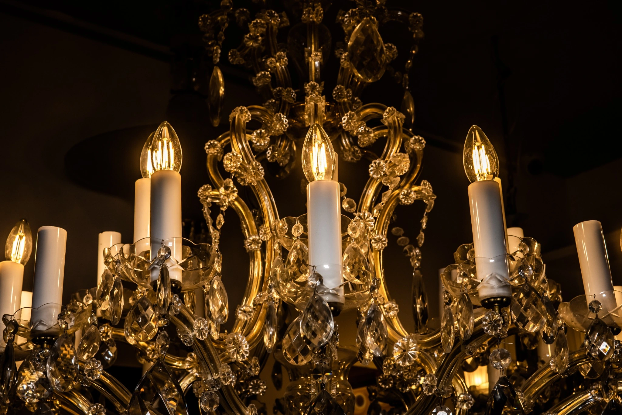 Detalle de una lámpara de línea María Teresa restaurada por Lámparas Escala, con elementos de cristal y ornamentación dorada.